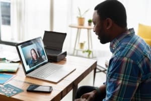 Man talking to a woman on a laptop video call