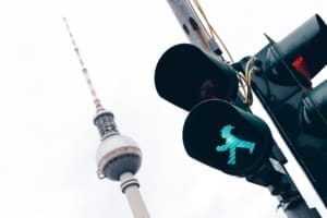 A green traffic light with the Berlin TV tower in the background