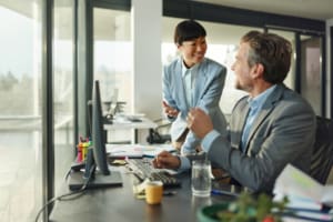 Happy business colleagues talking while working in the office.